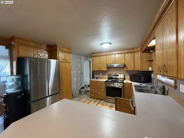 a kitchen with sink refrigerator and stove