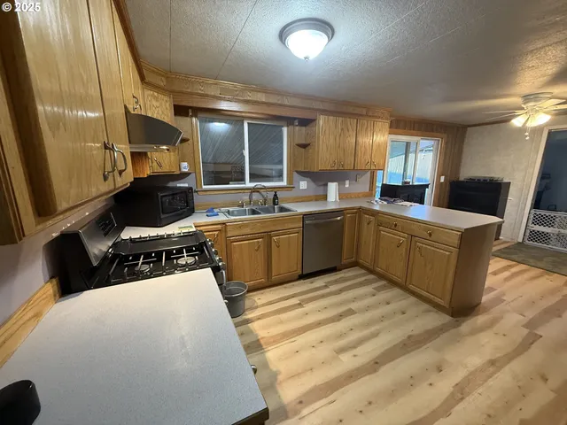 a kitchen with a sink a counter top space and stainless steel appliances