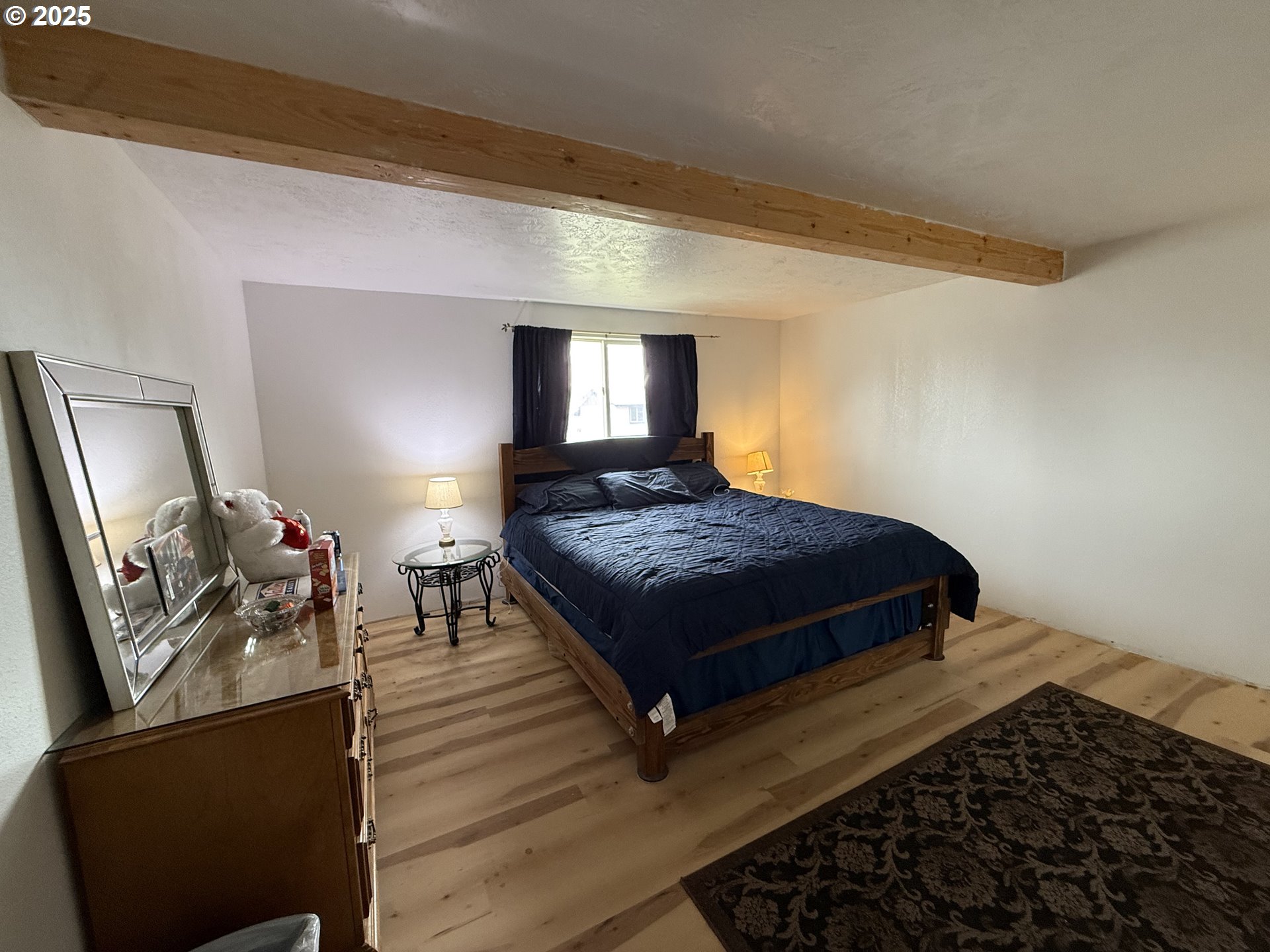 260 North 13th Street Elgin, OR 97827 - Photo 7 of 13 a bedroom with a bed and wooden floor