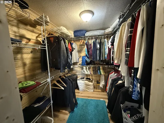 a view of walk in closet with clothes and shoes