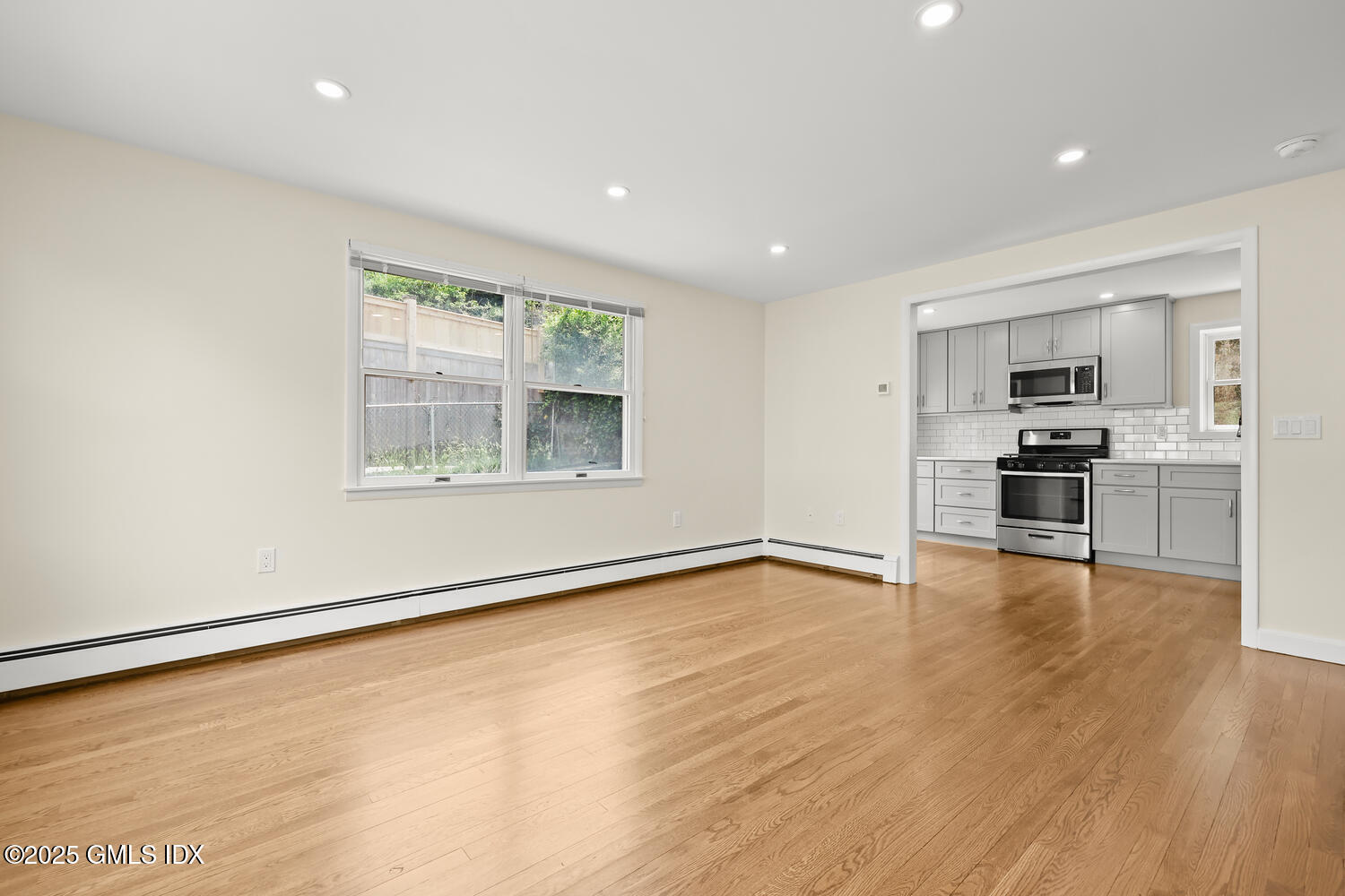 248 Byram Road, Unit L Greenwich, CT 06830 - Photo 4 of 17 a view of an empty room with wooden floor and a window