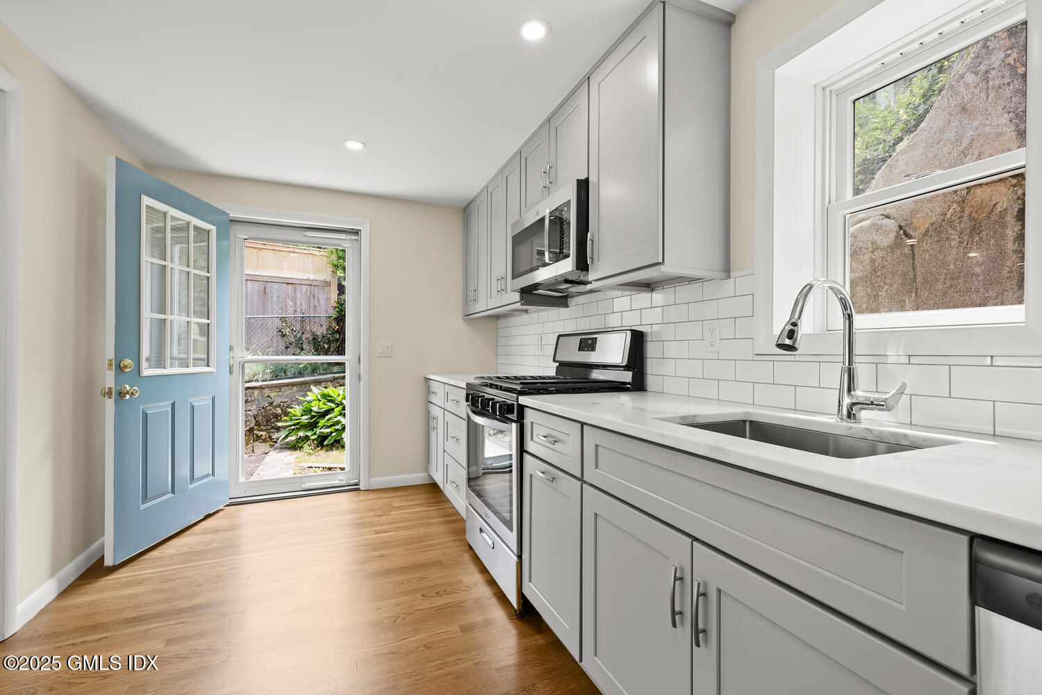 248 Byram Road, Unit L Greenwich, CT 06830 - Photo 5 of 17 a kitchen with stainless steel appliances granite countertop a sink and a stove top oven
