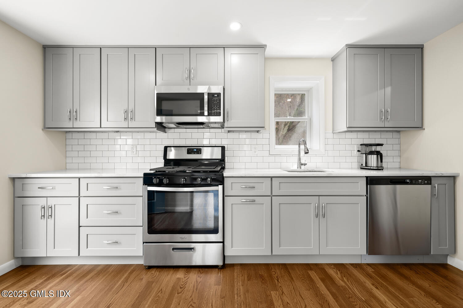 248 Byram Road, Unit L Greenwich, CT 06830 - Photo 6 of 17 a kitchen with stainless steel appliances granite countertop a stove a sink and a microwave