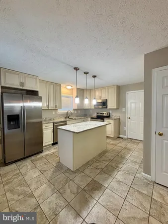 a kitchen with stainless steel appliances granite countertop a refrigerator sink and cabinets