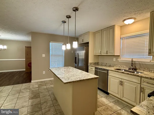 a kitchen with a sink a stove a refrigerator and island