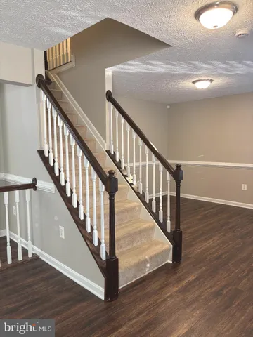 a view of staircase with wooden floor and front door