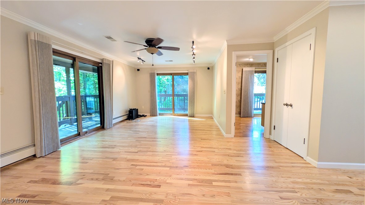 6409 Old Woods Road Ashtabula, OH 44004 - Photo 11 of 43 Expansive living area featuring wood-finish flooring, two sets of sliding glass doors, a ceiling fan, track lighting, and white baseboards