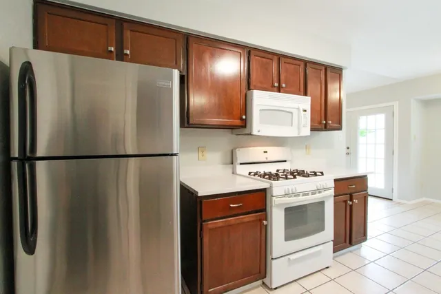 a kitchen with stainless steel appliances granite countertop a refrigerator a stove a sink and a microwave