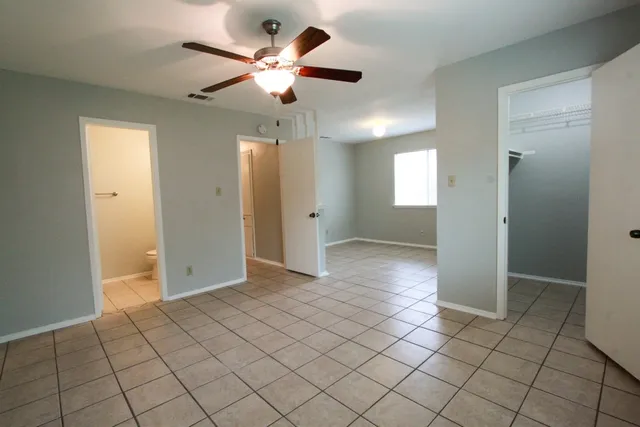 an empty room with closet and a chandelier fan