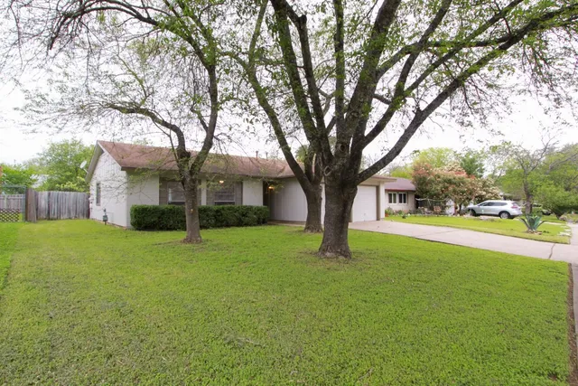 a view of a house with a large tree and a big yard