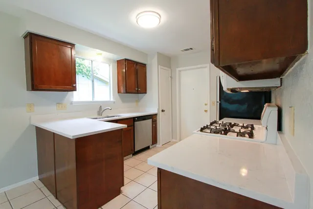 a kitchen that has a sink and a stove in it
