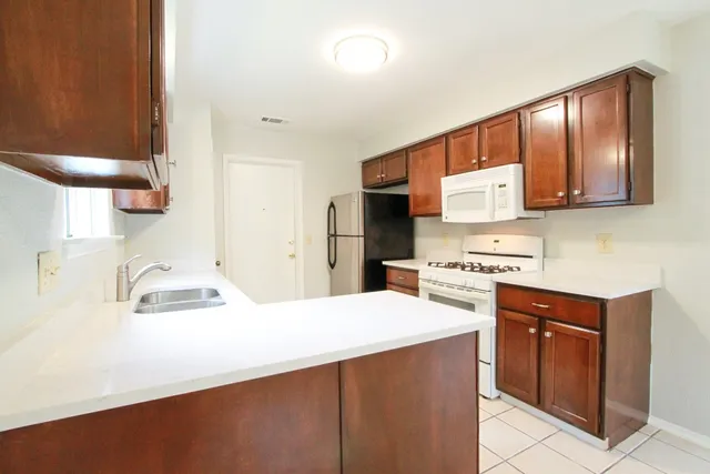 a kitchen with stainless steel appliances a sink stove and refrigerator