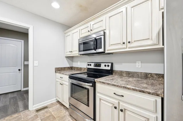 a kitchen with stainless steel appliances granite countertop a refrigerator stove and microwave