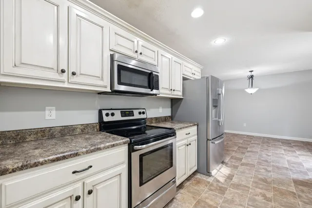 a kitchen with granite countertop a sink and a stove