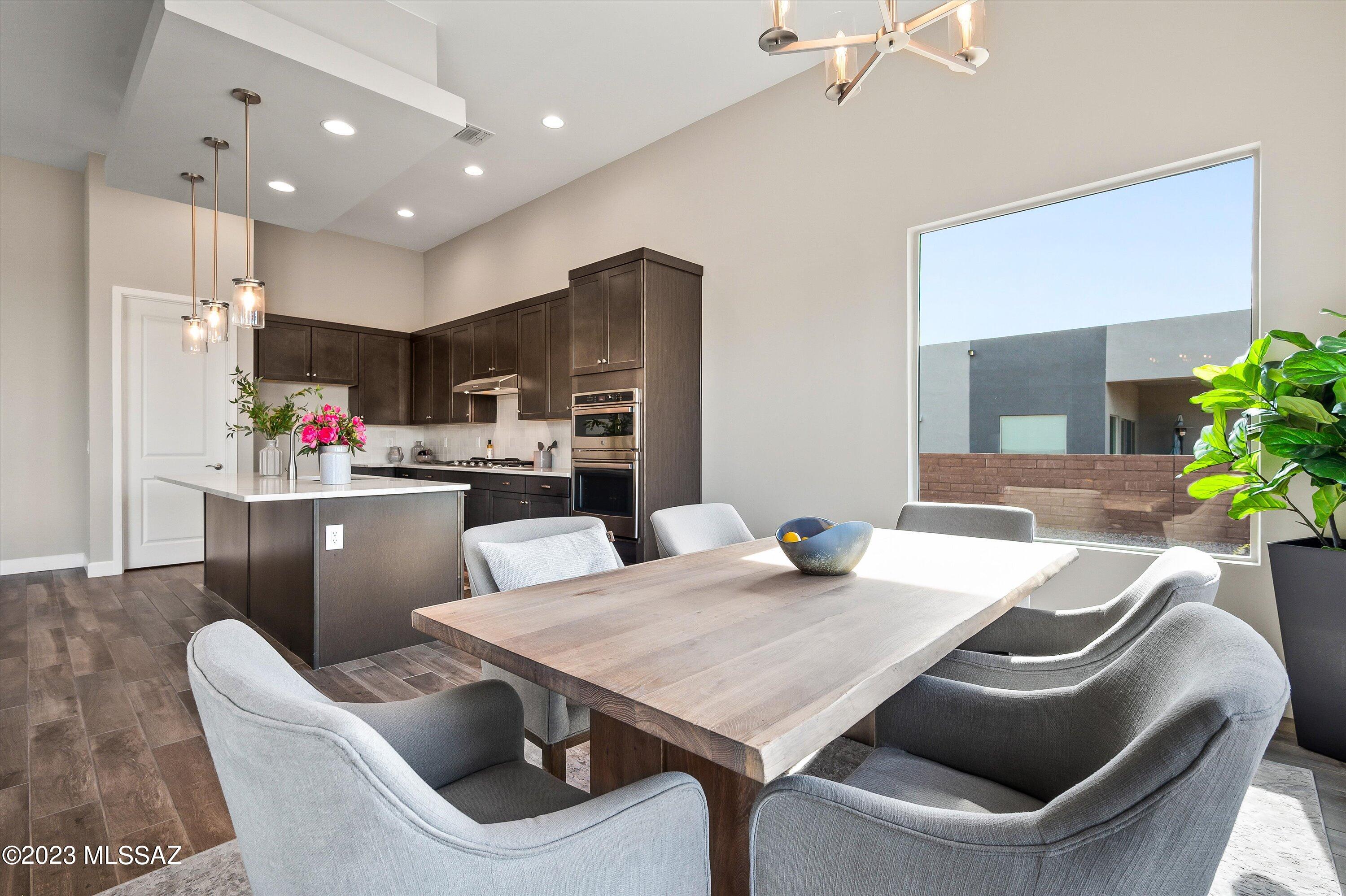 13169 North Vistoso Rnch Place Oro Valley, AZ 85755 - Photo 11 of 29 a kitchen with stainless steel appliances kitchen island granite countertop a dining table chairs and a refrigerator