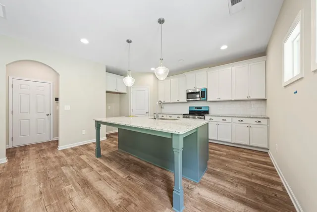a kitchen with kitchen island a sink stainless steel appliances and cabinets