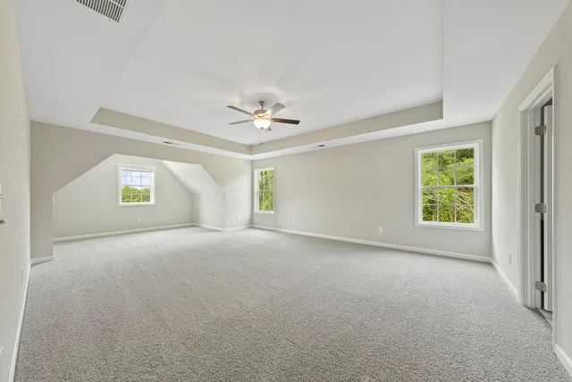 a view of a room with windows and chandelier fan