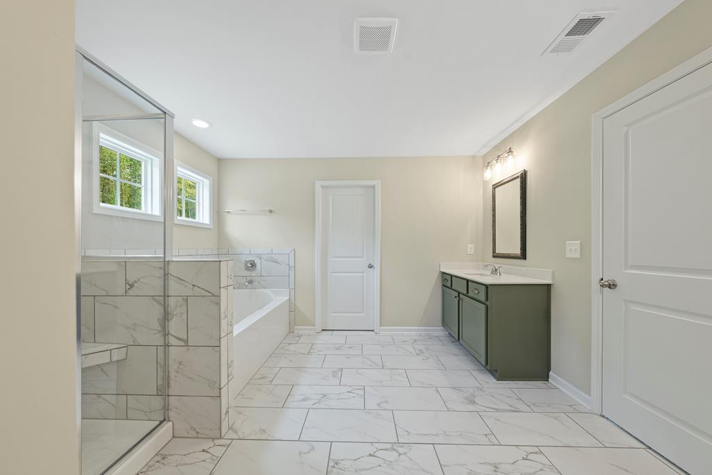 635 Bohannon Road Grantville, GA 30220 - Photo 27 of 43 a spacious bathroom with a granite countertop sink a mirror and a bathtub