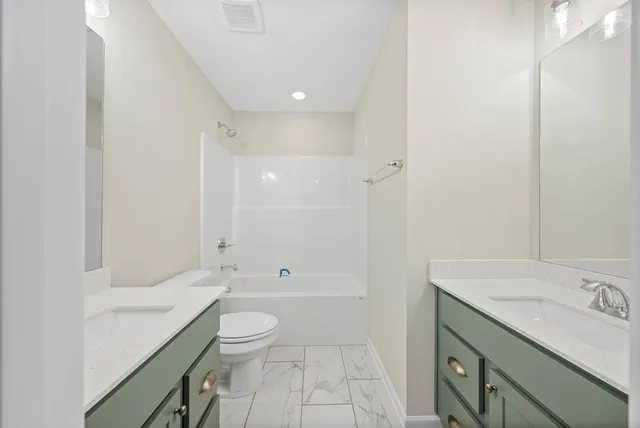 a bathroom with a granite countertop sink a toilet and shower