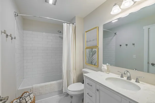 a bathroom with a sink a toilet and shower a mirror