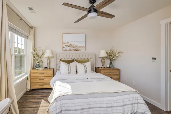a bedroom with a large bed and a chandelier