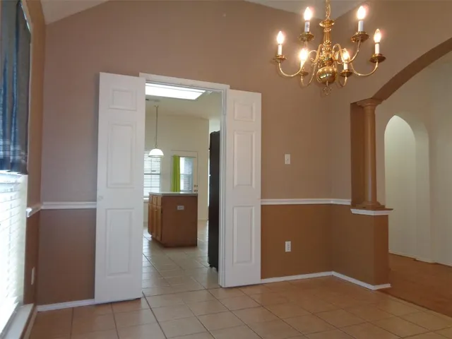 a view of a hallway with wooden floor and chandelier