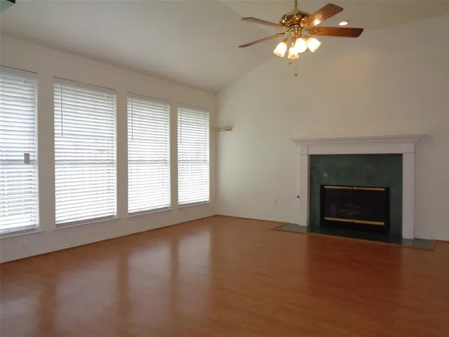 an empty room with windows and fireplace