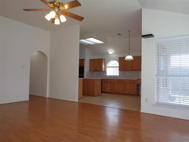 a view of a room with a ceiling fan and window