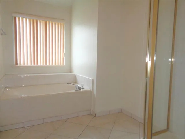 a white bath tub sitting in a bathroom next to a window
