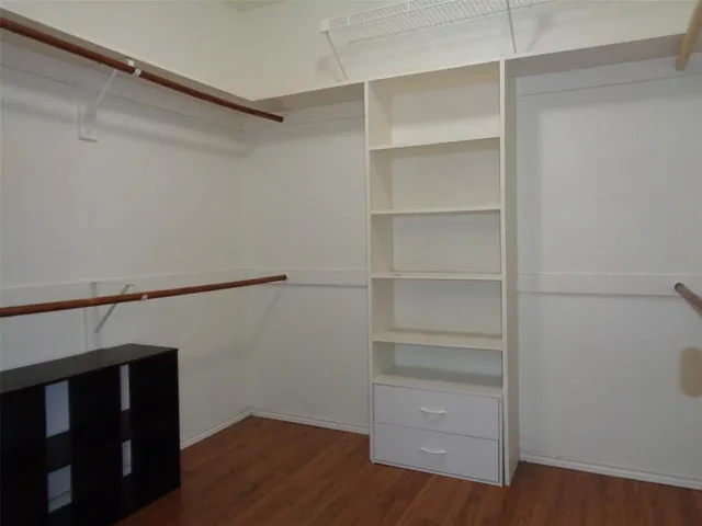 a view of walk in closet with empty racks
