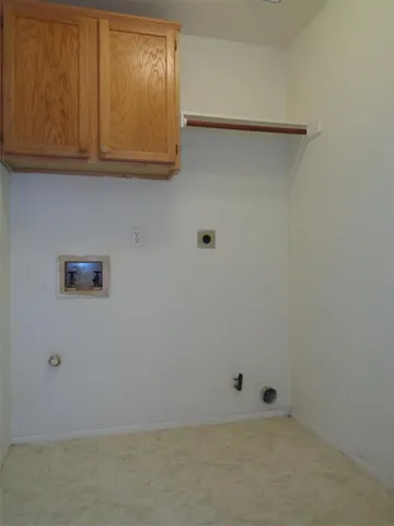 an empty room with kitchen view and natural light