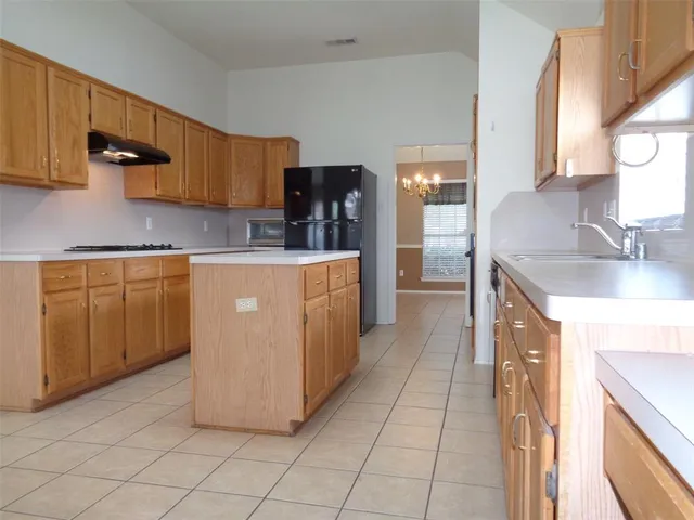 a kitchen with kitchen island granite countertop a sink counter top space and cabinets