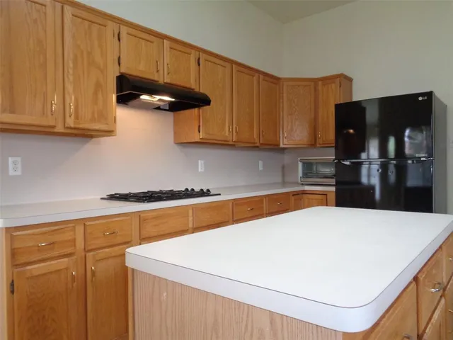 a kitchen with stainless steel appliances a refrigerator a sink a stove and cabinets