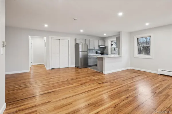 a view of empty room with wooden floor and window