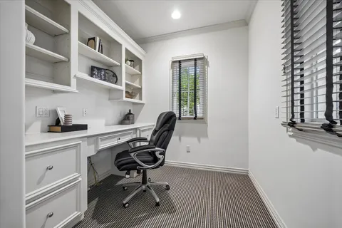 a view of a workspace with furniture and a window