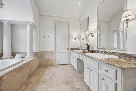a bathroom with a granite countertop sink mirror and a bathtub