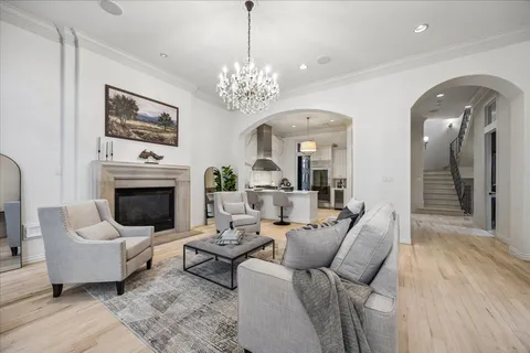 a living room with furniture a chandelier and a fireplace