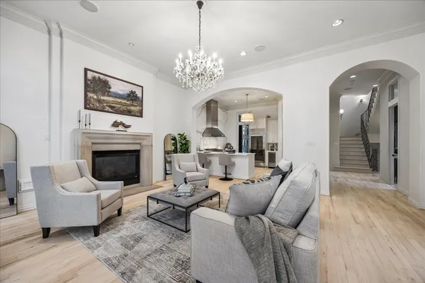 a living room with furniture a chandelier and a fireplace