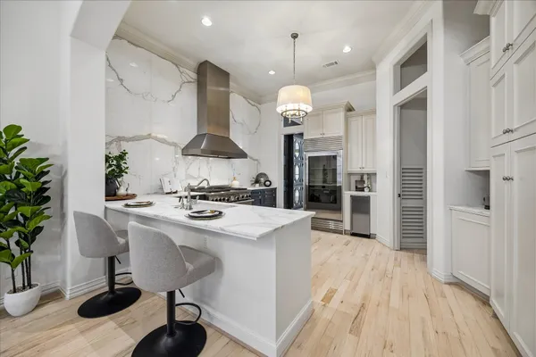a kitchen with stainless steel appliances granite countertop a sink a stove and a wooden floors