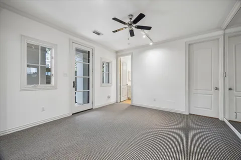 a view of a livingroom with a ceiling fan & windows