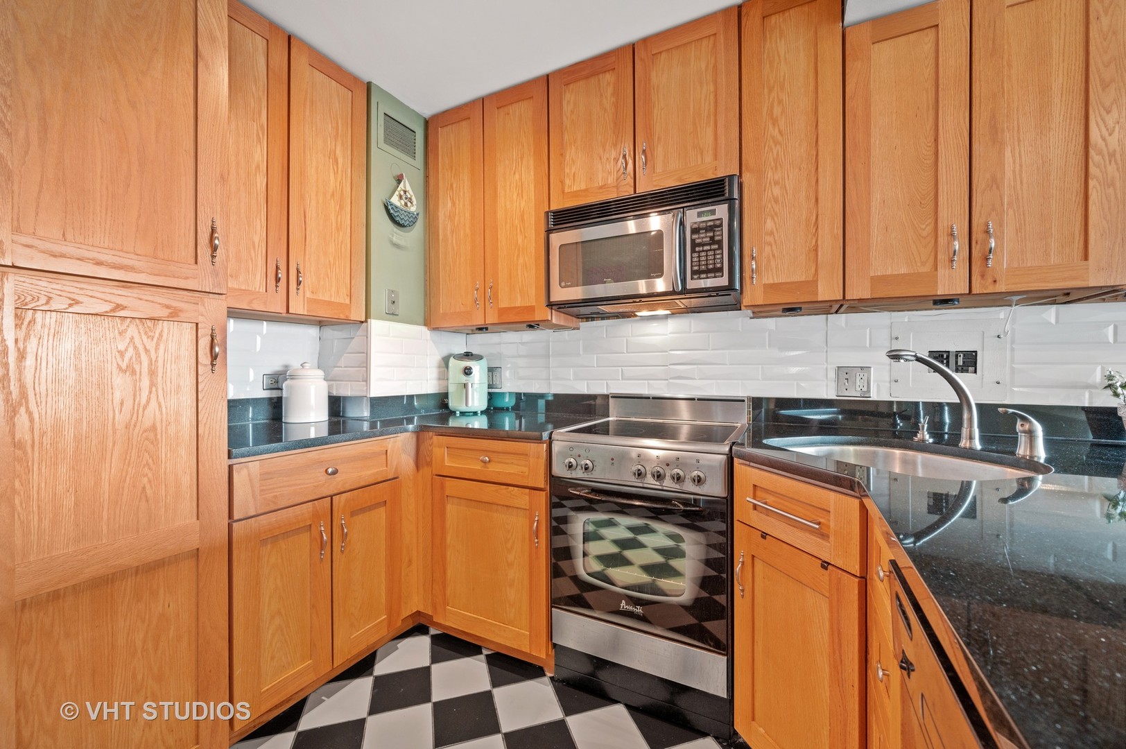 2909 North Sheridan Road, Unit 1105 Chicago, IL 60657 - Photo 7 of 11 a kitchen with stainless steel appliances granite countertop a refrigerator sink and cabinets