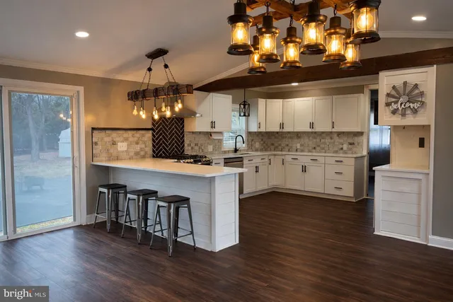 a kitchen with kitchen island granite countertop a sink cabinets and wooden floor