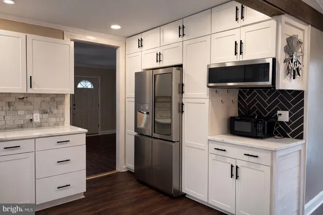 a kitchen with white cabinets and stainless steel appliances