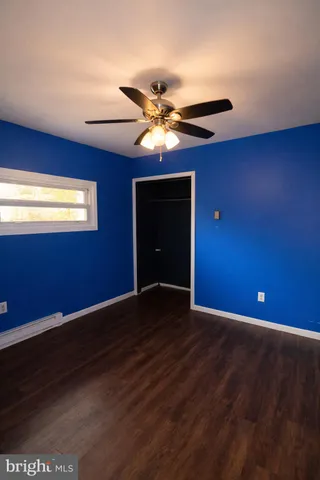 a view of an empty room with window and a ceiling fan
