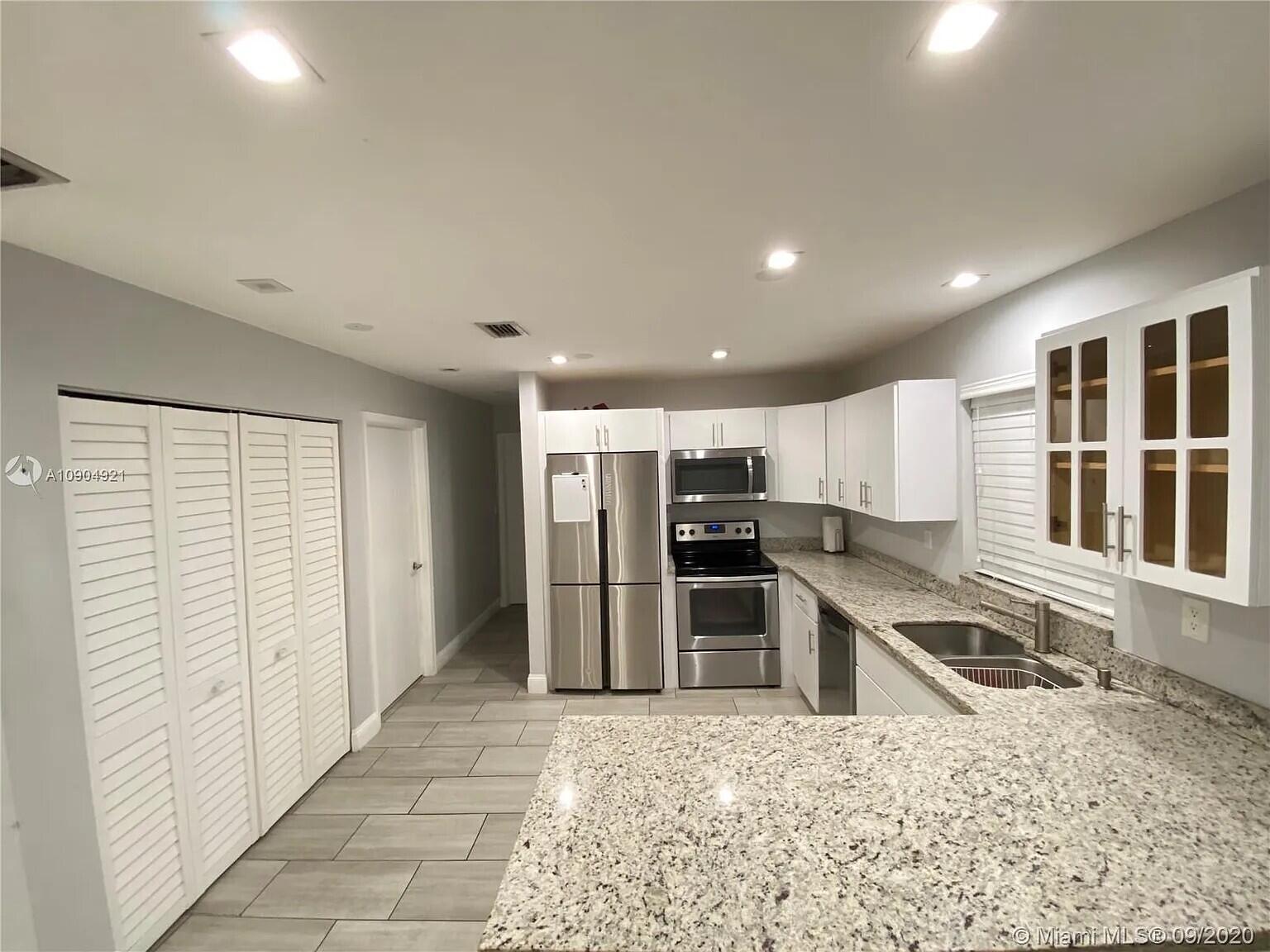 2633 Southwest 30th Court Miami, FL 33133 - Photo 20 of 24 a kitchen with stainless steel appliances kitchen island granite countertop a refrigerator and a sink