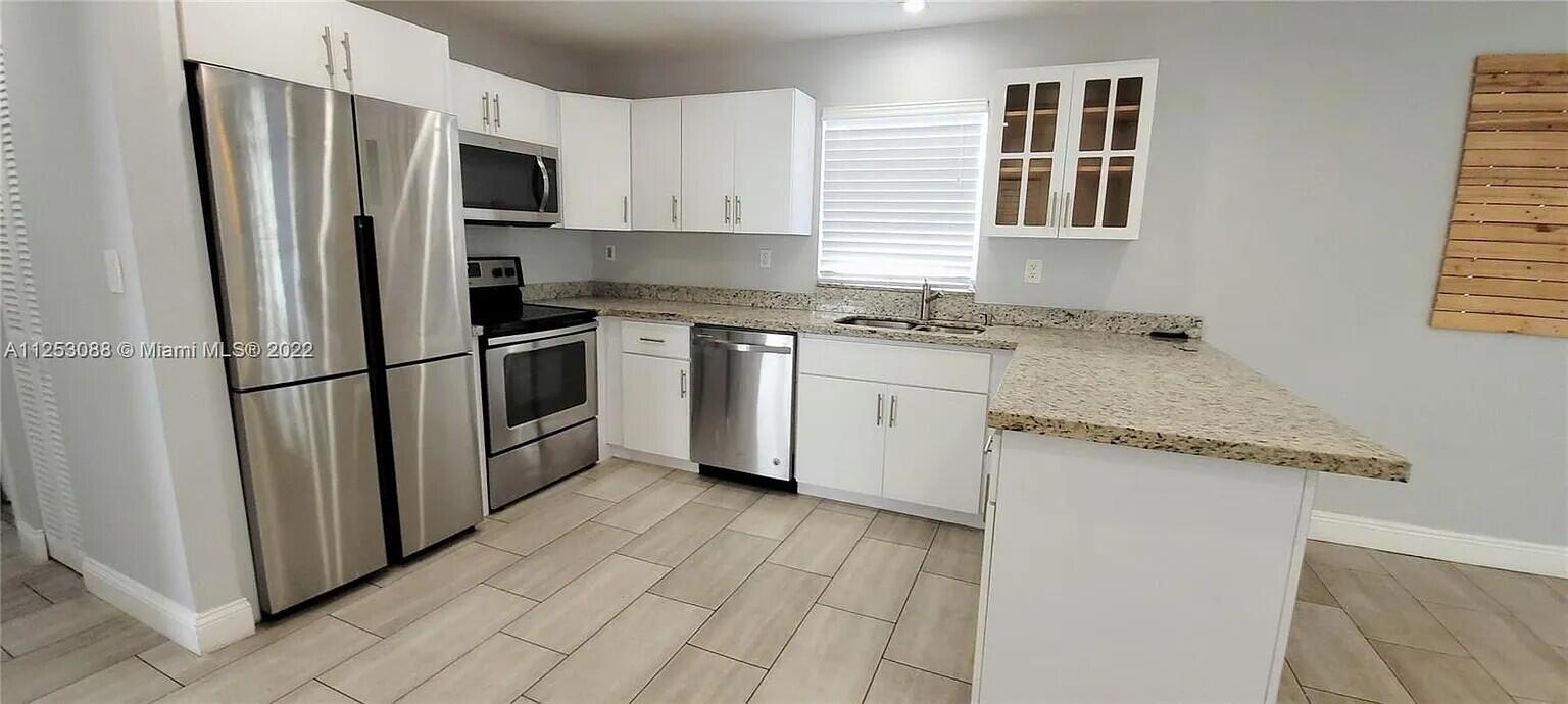 2633 Southwest 30th Court Miami, FL 33133 - Photo 6 of 24 a kitchen with granite countertop a refrigerator stove and sink
