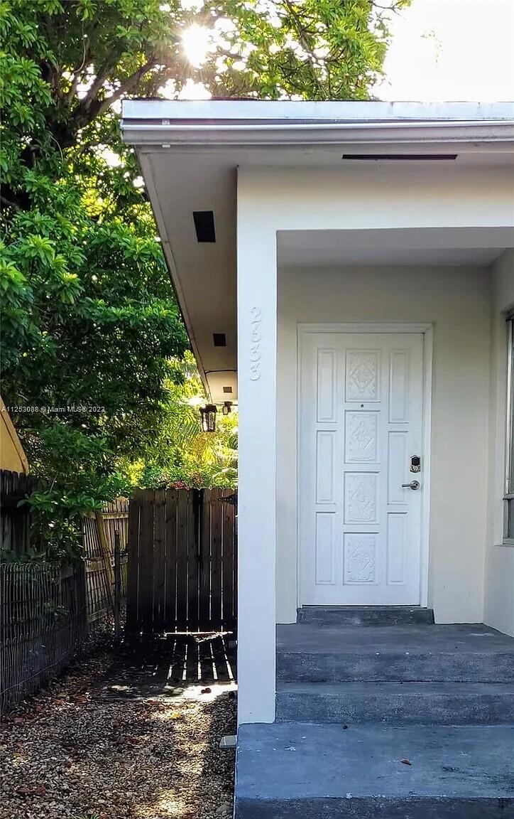 2633 Southwest 30th Court Miami, FL 33133 - Photo 9 of 24 a view of a house with a small yard and wooden fence