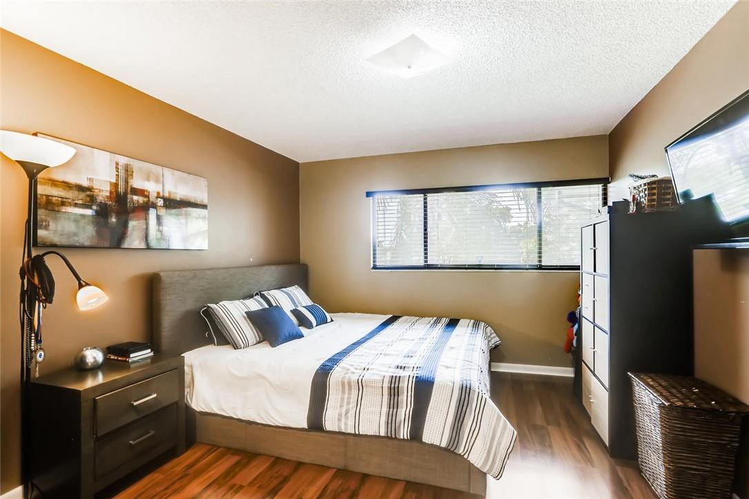 9763 West McNab Road, Unit 214 Tamarac, FL 33321 - Photo 11 of 28 a bedroom with a bed and a flat tv screen on a dresser
