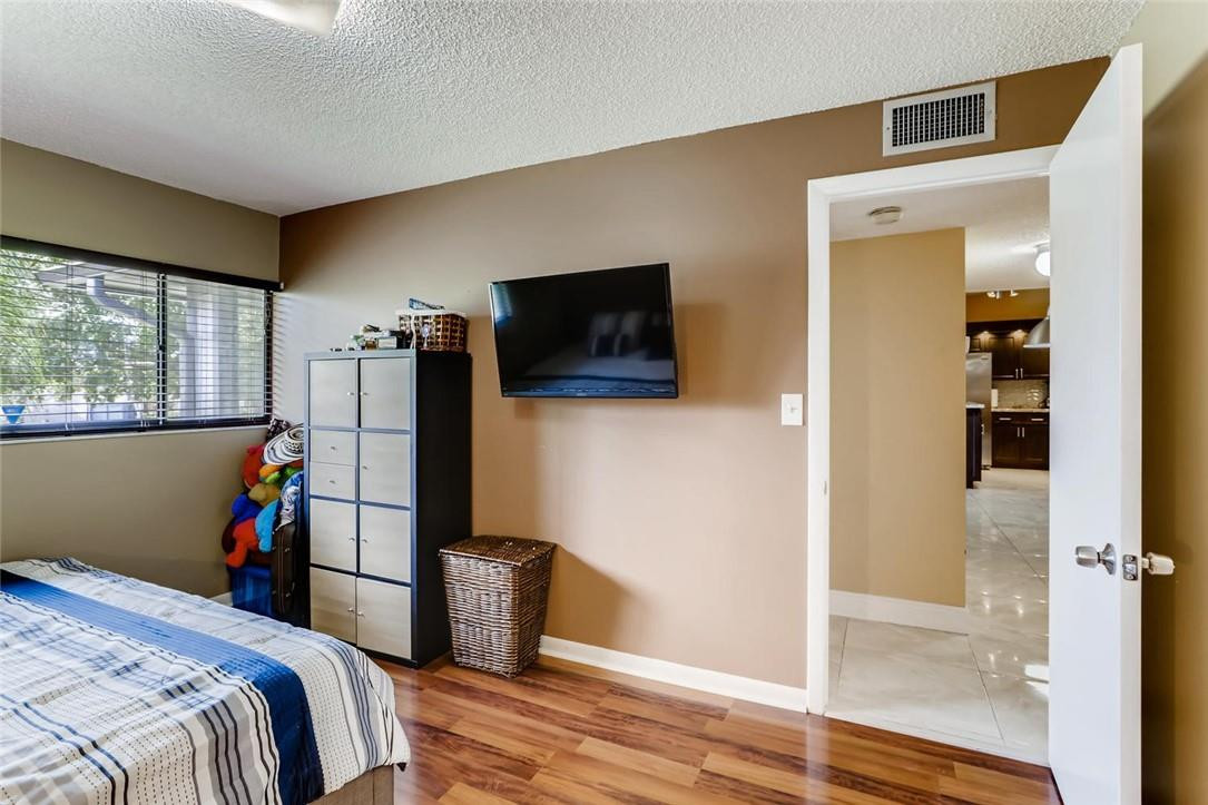 9763 West McNab Road, Unit 214 Tamarac, FL 33321 - Photo 13 of 28 a bedroom with a bed and a flat screen tv