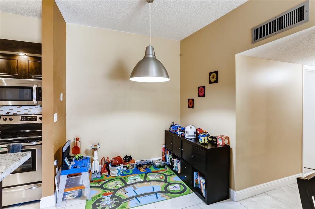 9763 West McNab Road, Unit 214 Tamarac, FL 33321 - Photo 10 of 28 a living room with furniture and a flat screen tv